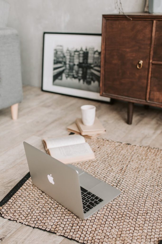 Laptop and books on floor carpet